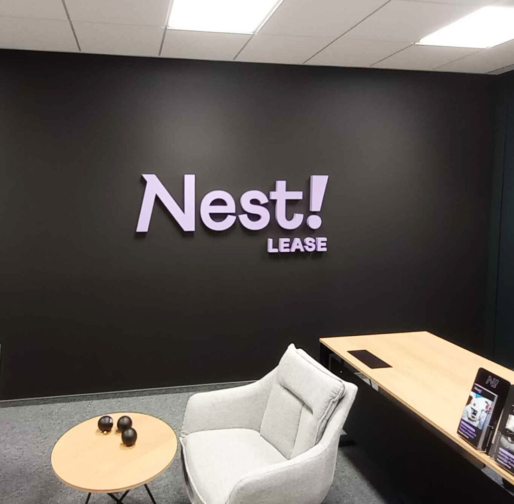 Logo NEST Lease na ścianie po rebrandingu sieci