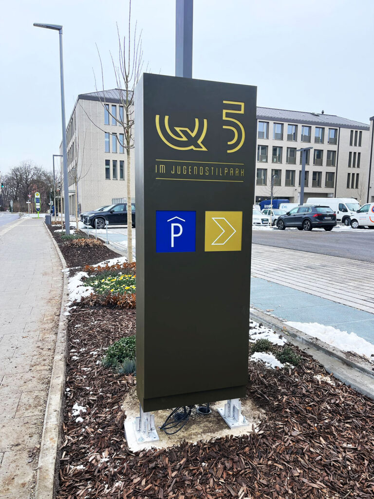 Wolnostojący pylon reklamowy przed budynkiem