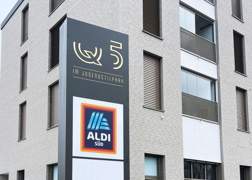 Podświetlany pylon aluminiowy Aldi przed obiektem handlowym